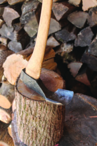 An adze turned upside down and balanced on a log